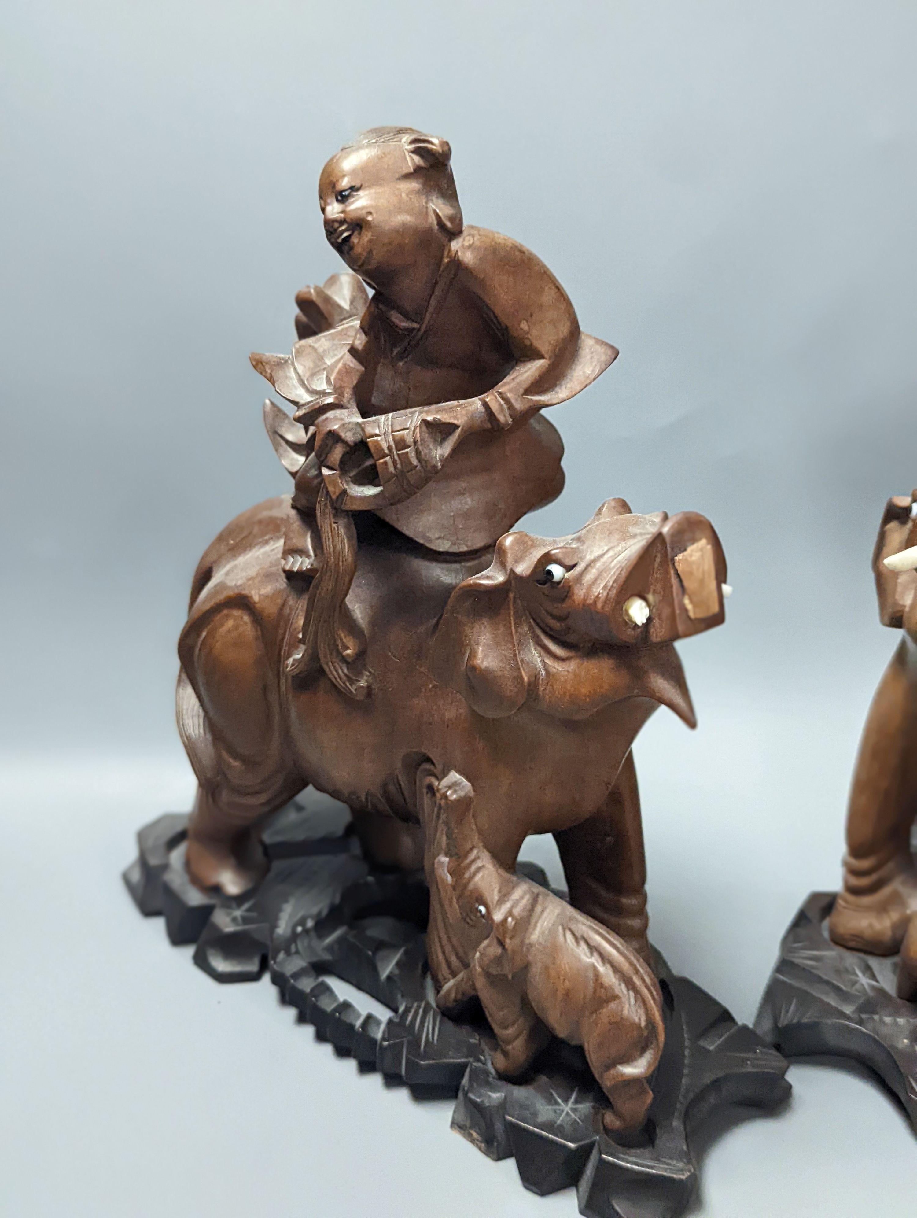 A pair of Chinese wood carvings figures on elephants, a pair of Chinese bear bookends, Chines figures 26 cms high.